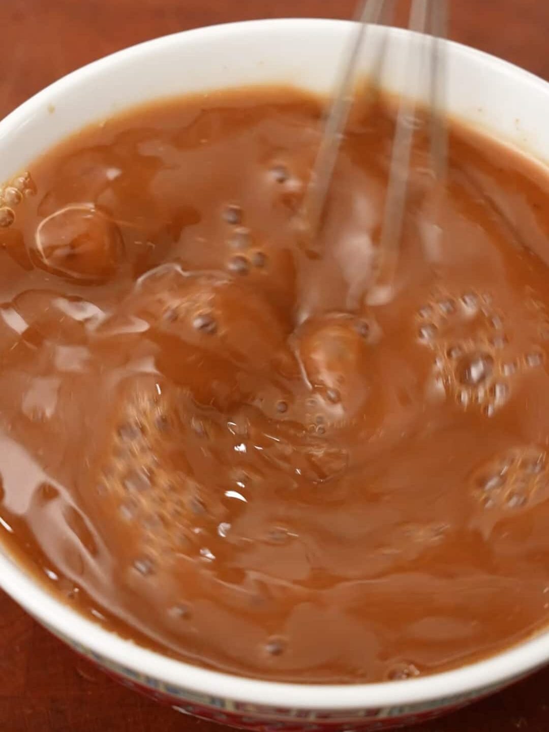 A small whisk mixing together the sauce for Chinese Chicken and Broccoli.