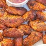 A tray of Grilled Chicken Wings with bbq sauce and ranch dressing.