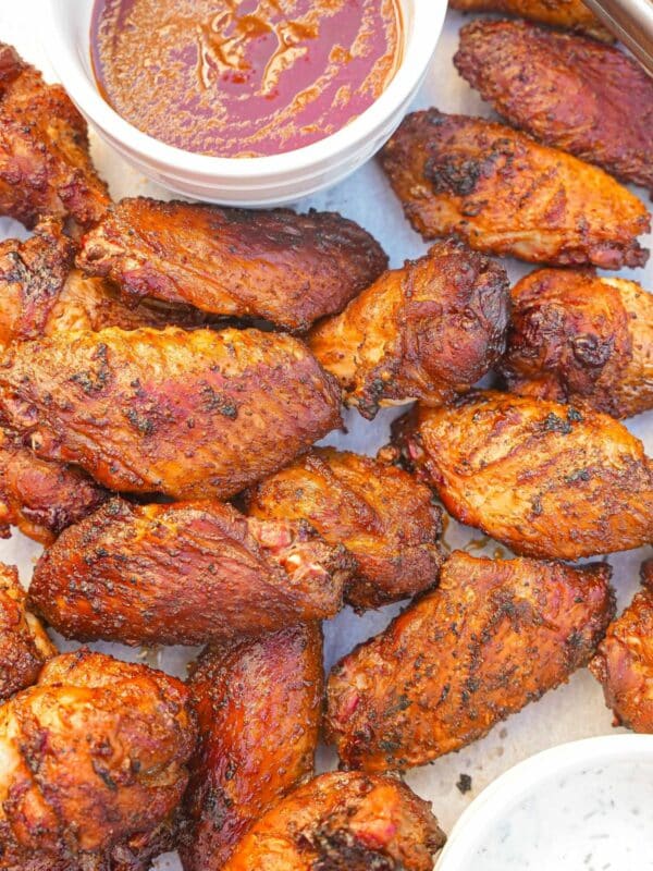 A tray of Grilled Chicken Wings with bbq sauce and ranch dressing.