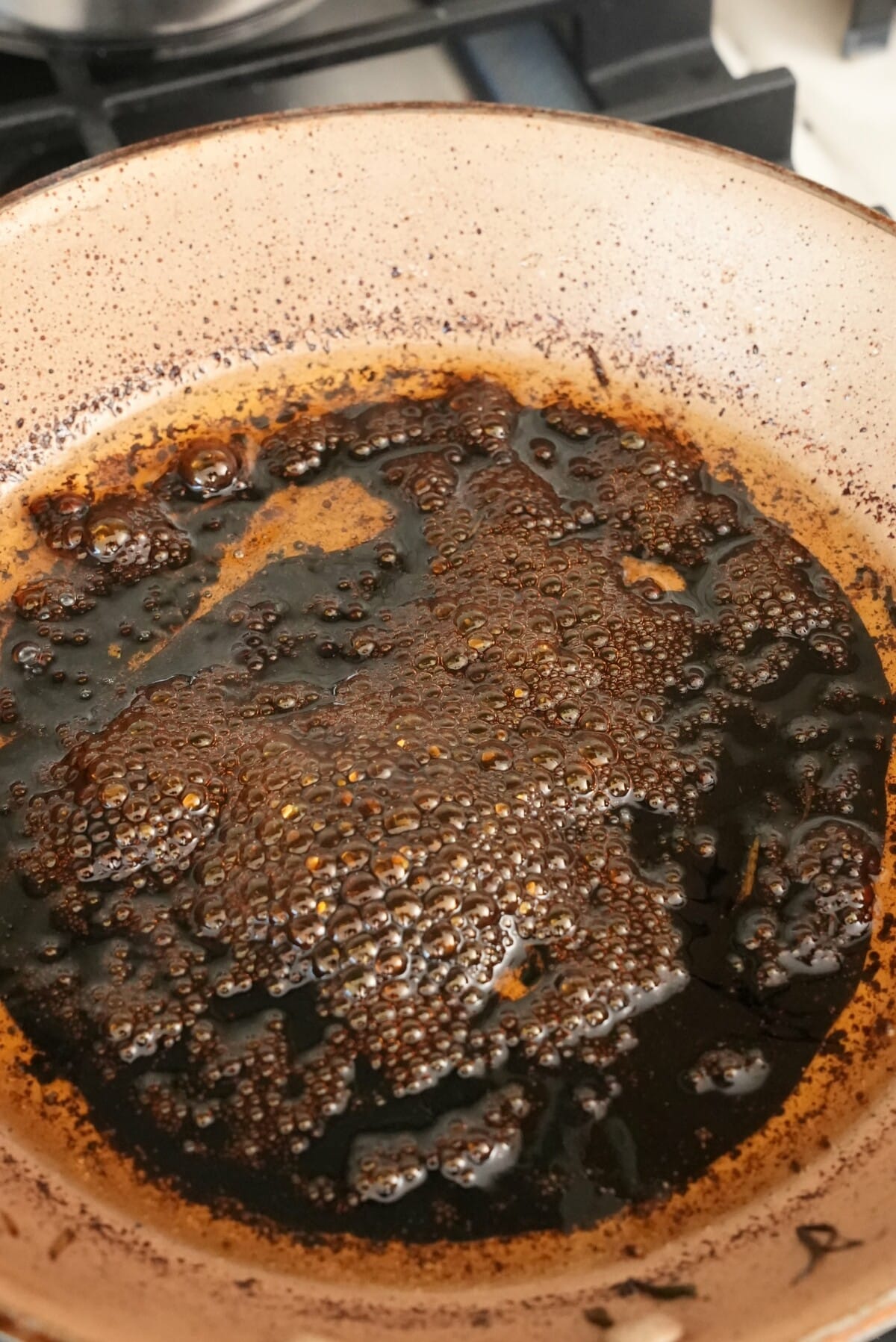 Light and dark soy sauce along with seasonings cooking in a pan.