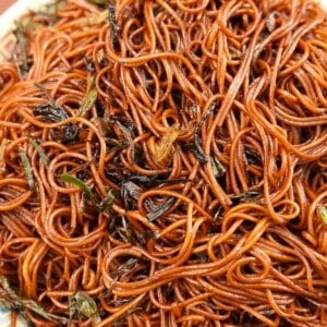 Scallion oil noodles cooked on a white plate.