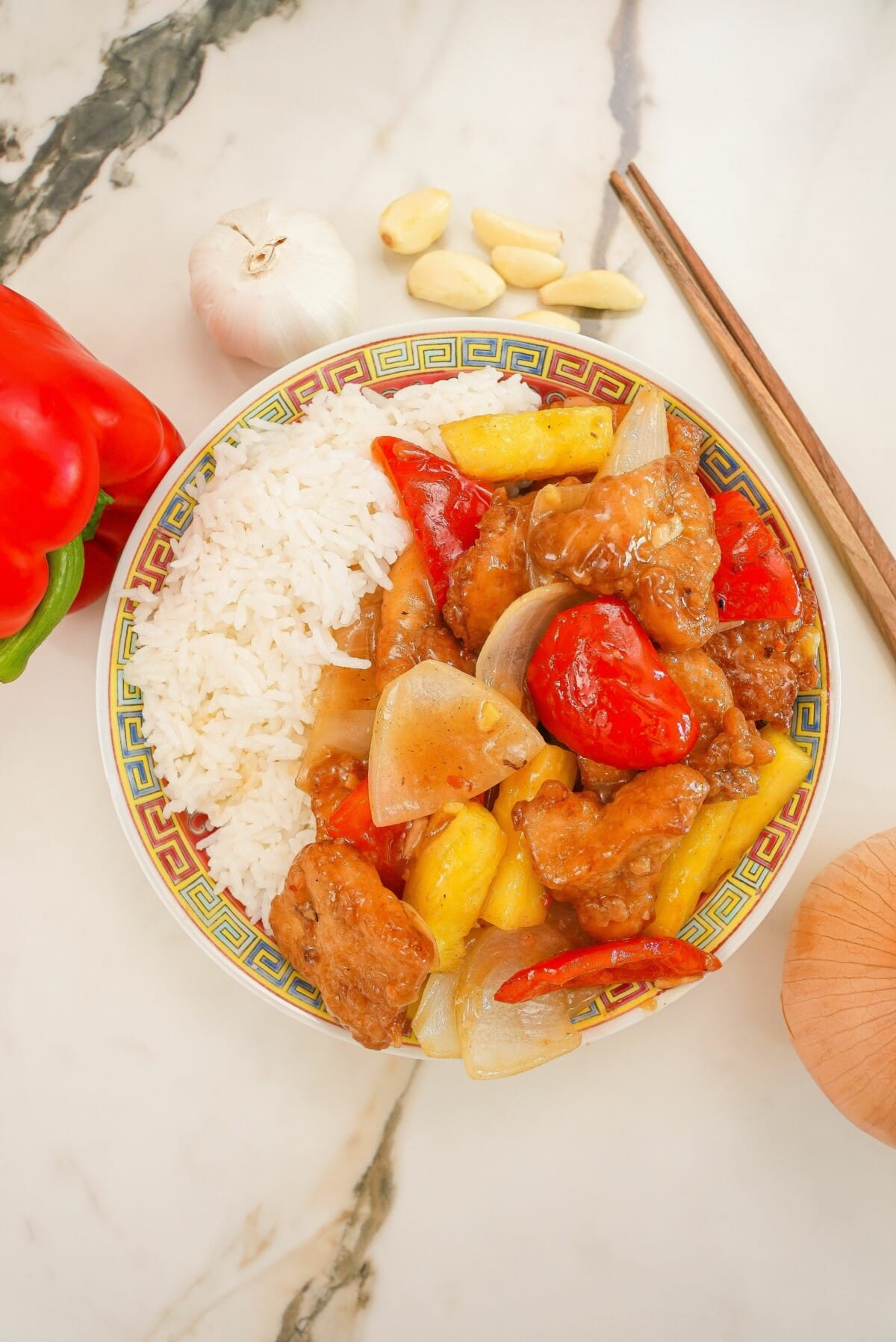 Sweetfire Chicken Breast on a plate with white rice and a pair of chopsticks.