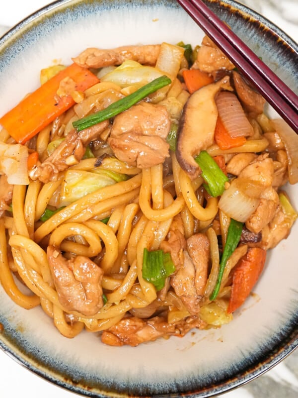 Yaki Udon in a bowl with a pair of chopsticks.