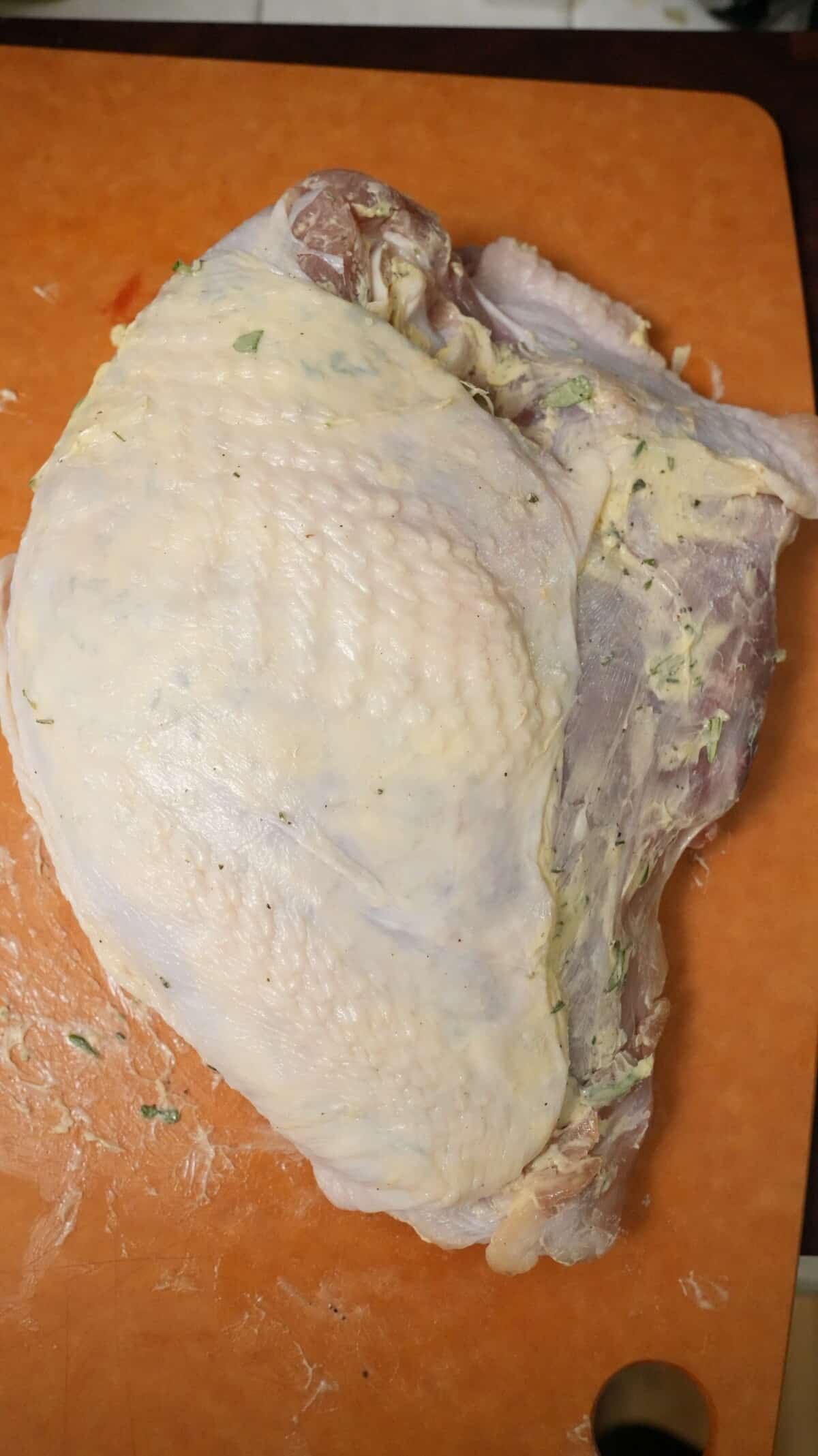 A fully seasoned turkey breast with compound butter underneath the skin and baking powder rubbed into the skin.