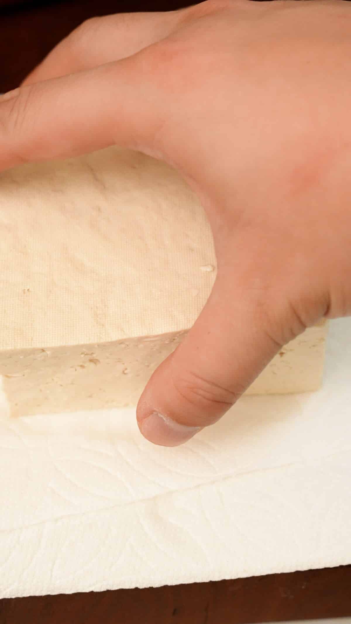 A block of tofu on folded paper towels.