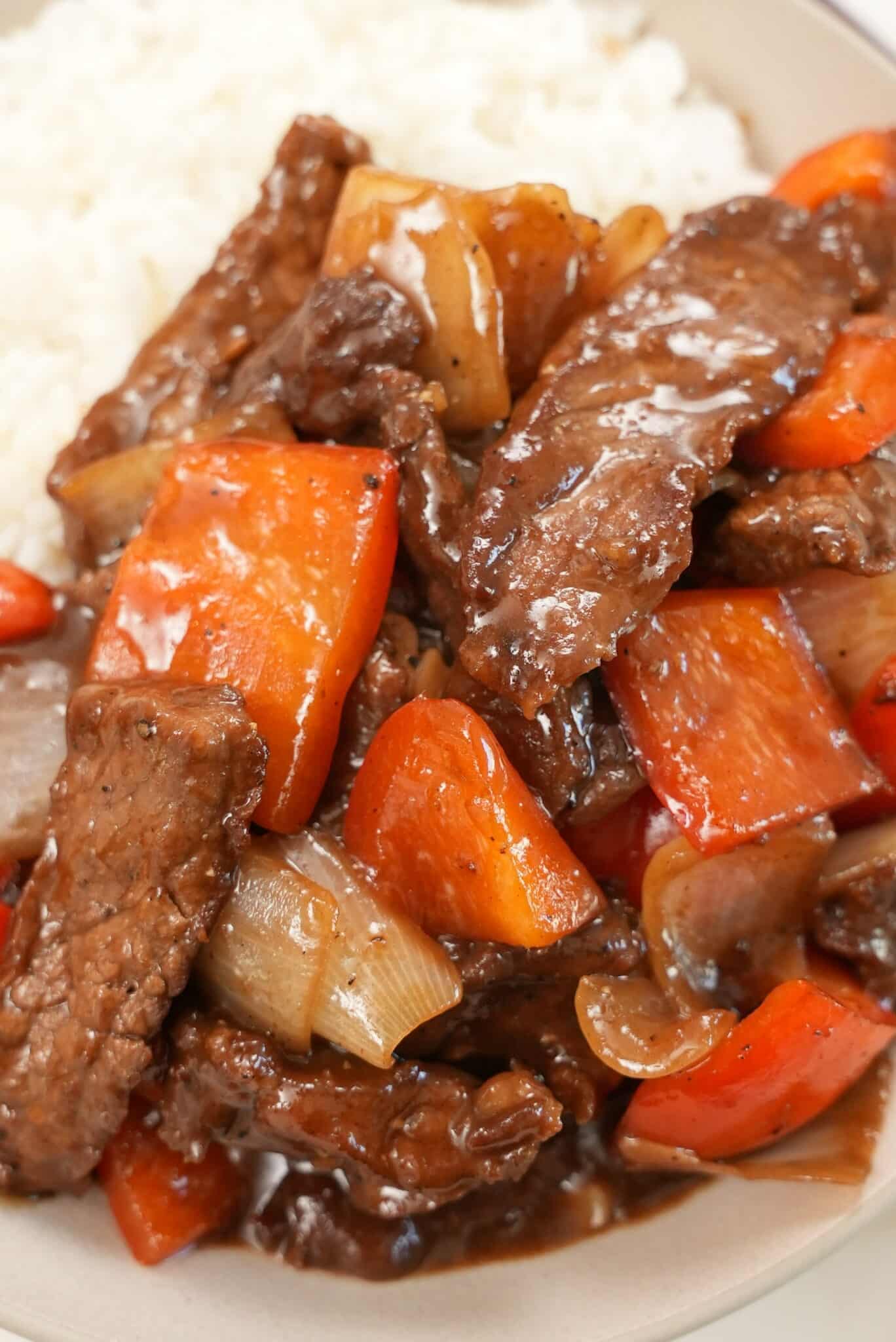 Black Pepper Beef in a bowl with a side of white rice.