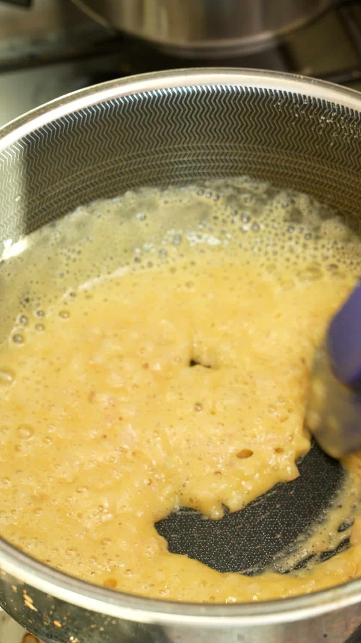 A roux being cooked in a pot for creamed spinach.