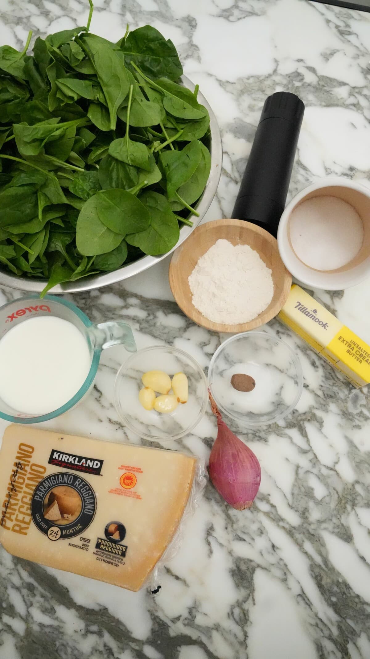 Raw ingredients for creamed spinach on a table.