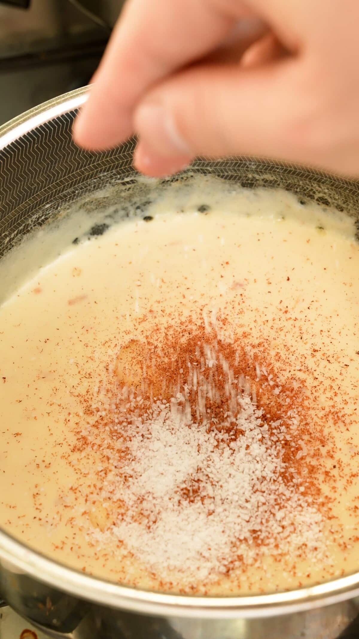 Seasoning the roux with spices in a pot.