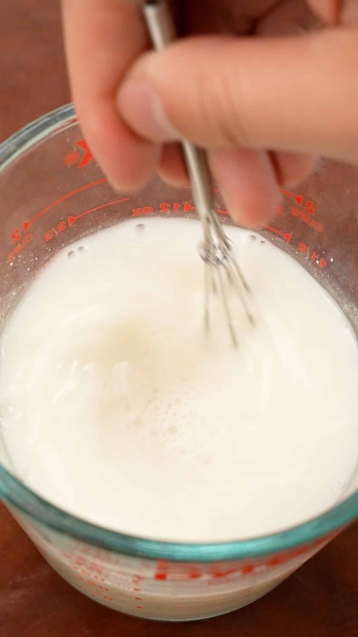 Mixing dumpling skirt batter in a measuring cup.