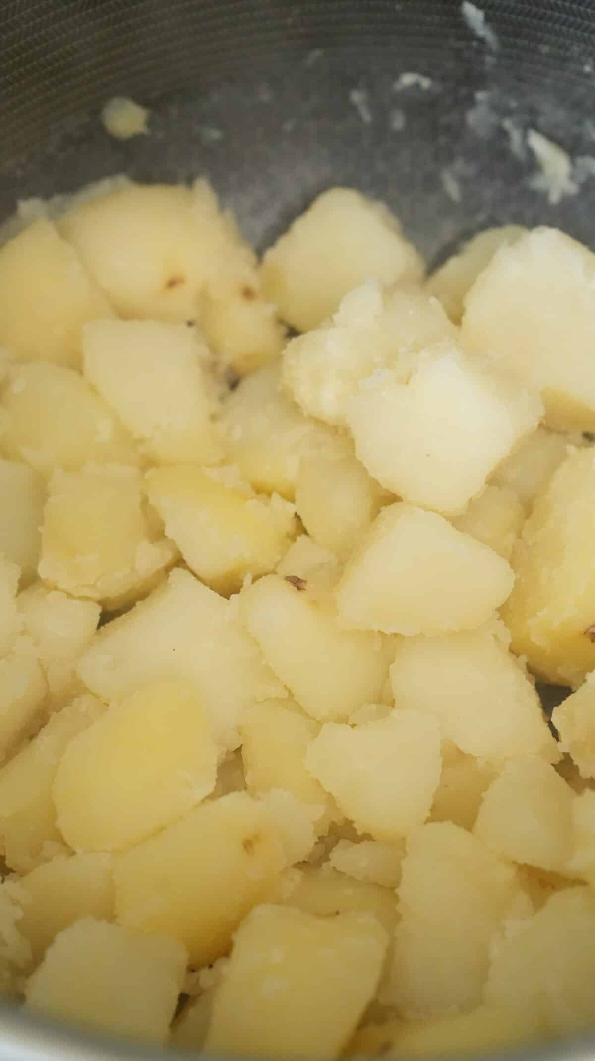 Potatoes added back to the drained pot.