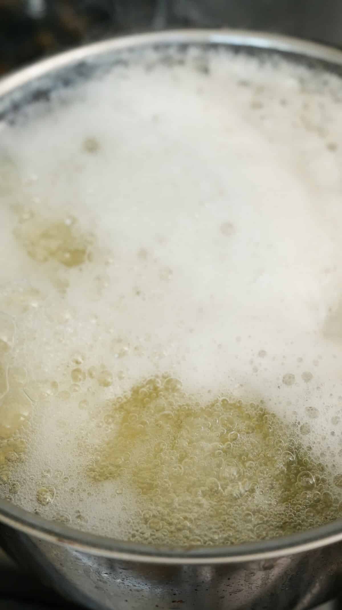 Potatoes boiling in a pot of water with salt and baking soda.