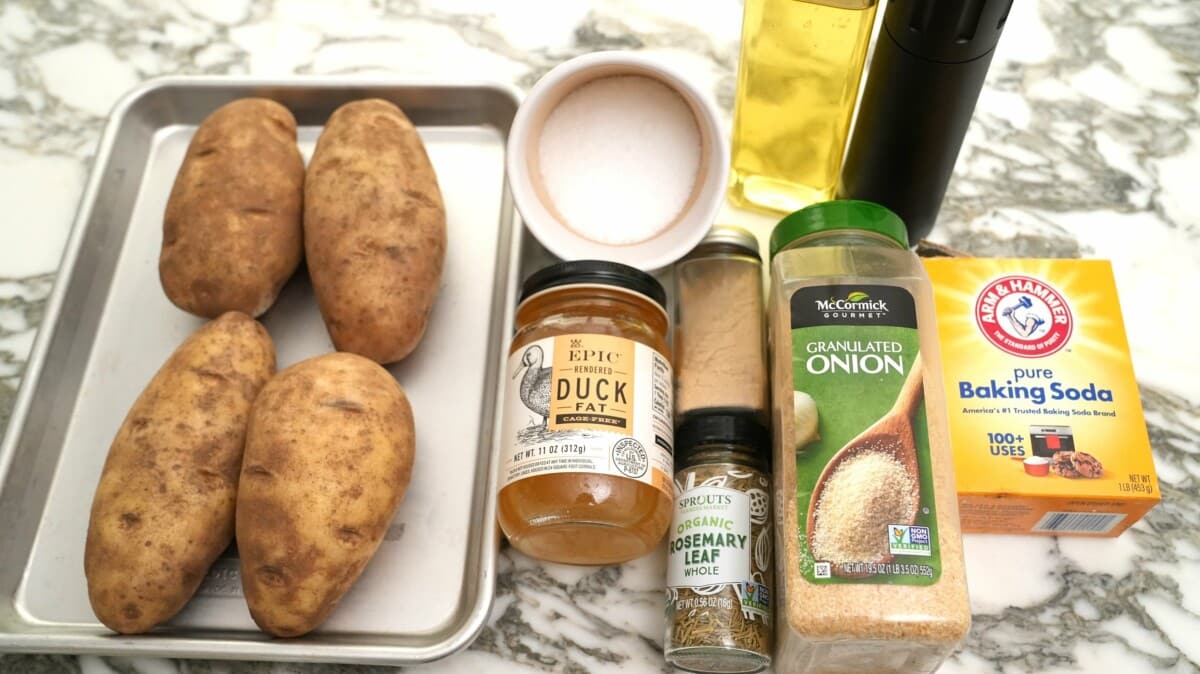 Raw ingredients for perfect roasted potatoes on a table.