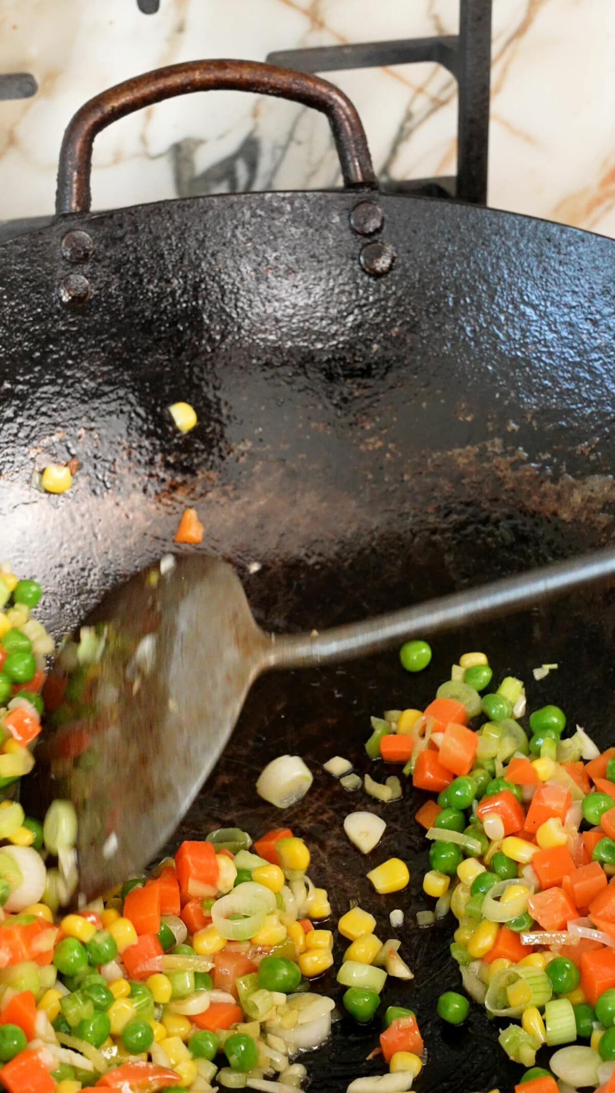 Stir frying vegetables in the wok with aromatics.