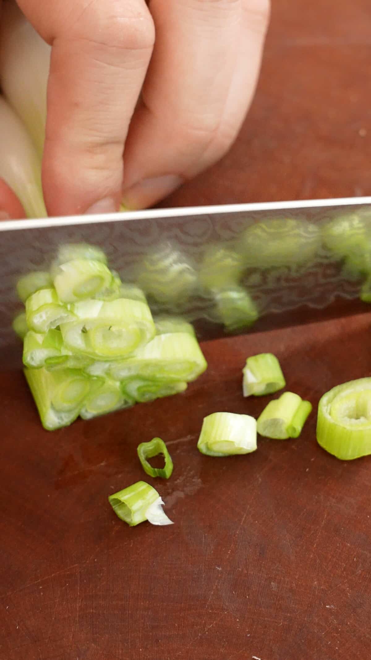 Preparing vegetables for egg fried rice on a cutting board.