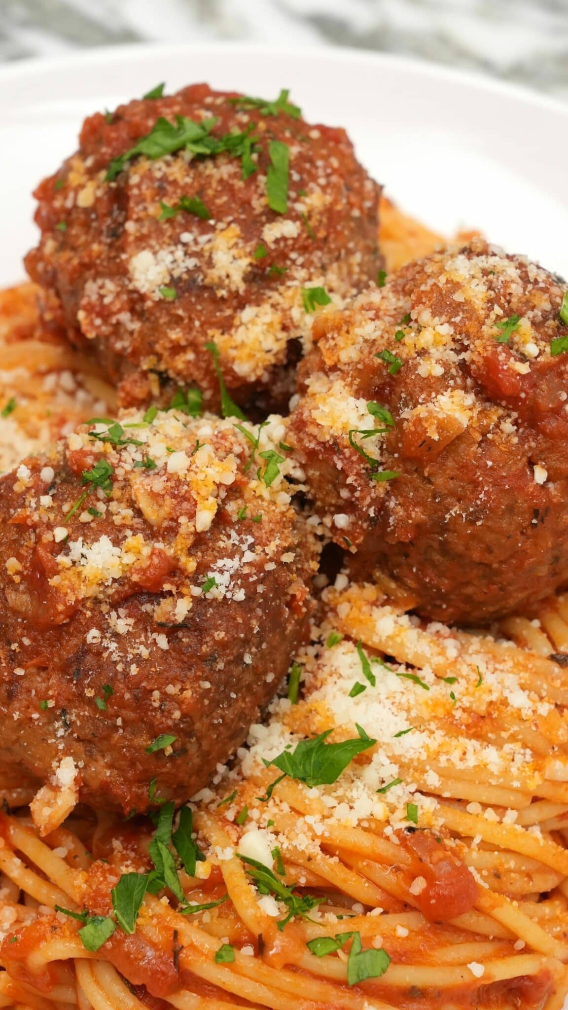 Spaghetti and Meatballs on a white plate.