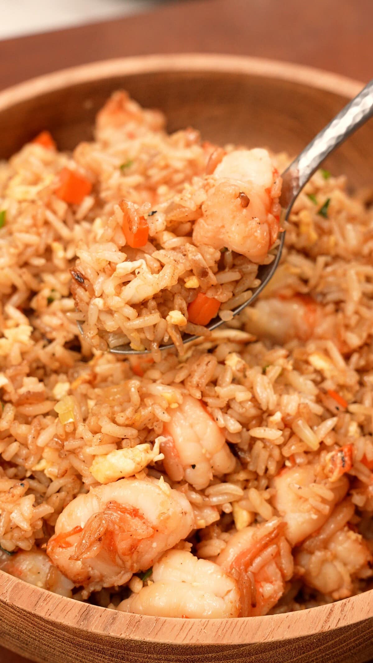 A spoon with Benihana Fried Rice in a bowl.