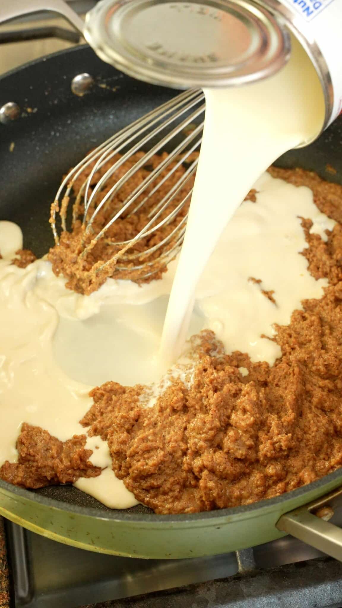 Adding evaporated milk into the roux.