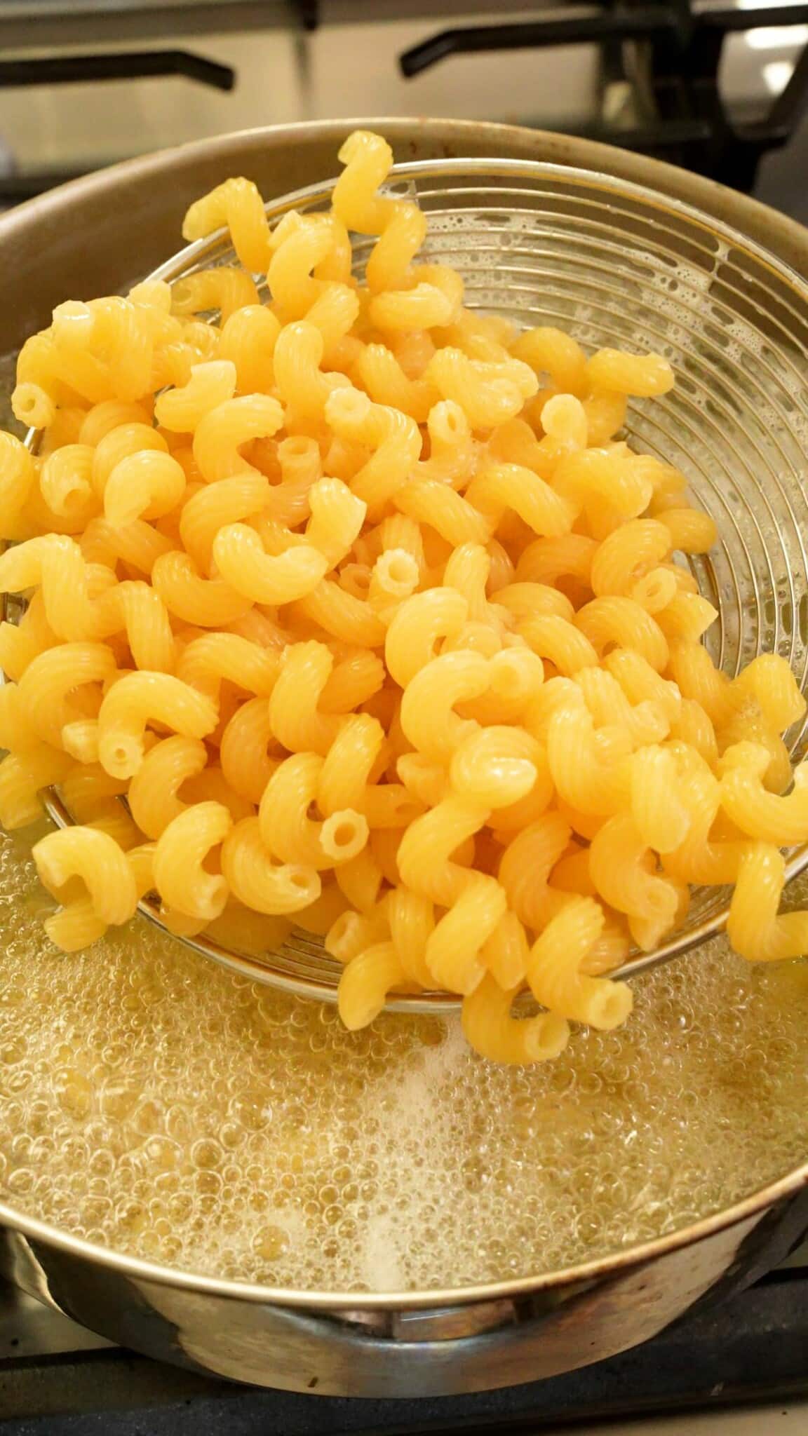 Cooked cavatappi pasta being drained from the pot.