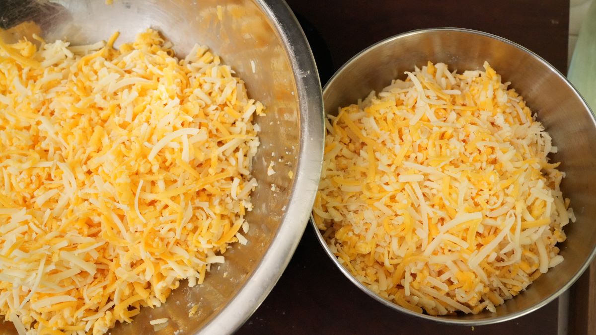 Shredded cheese divided in two separate bowls.