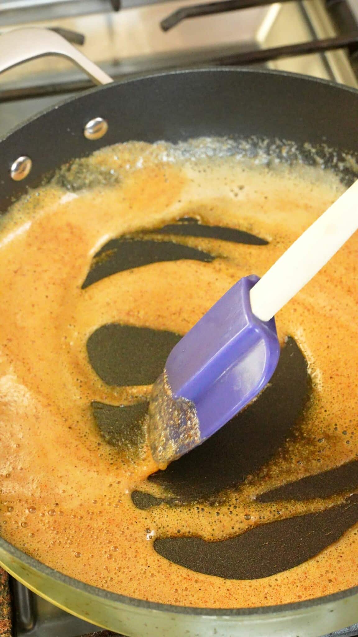 Cooking spices in butter in a pan.