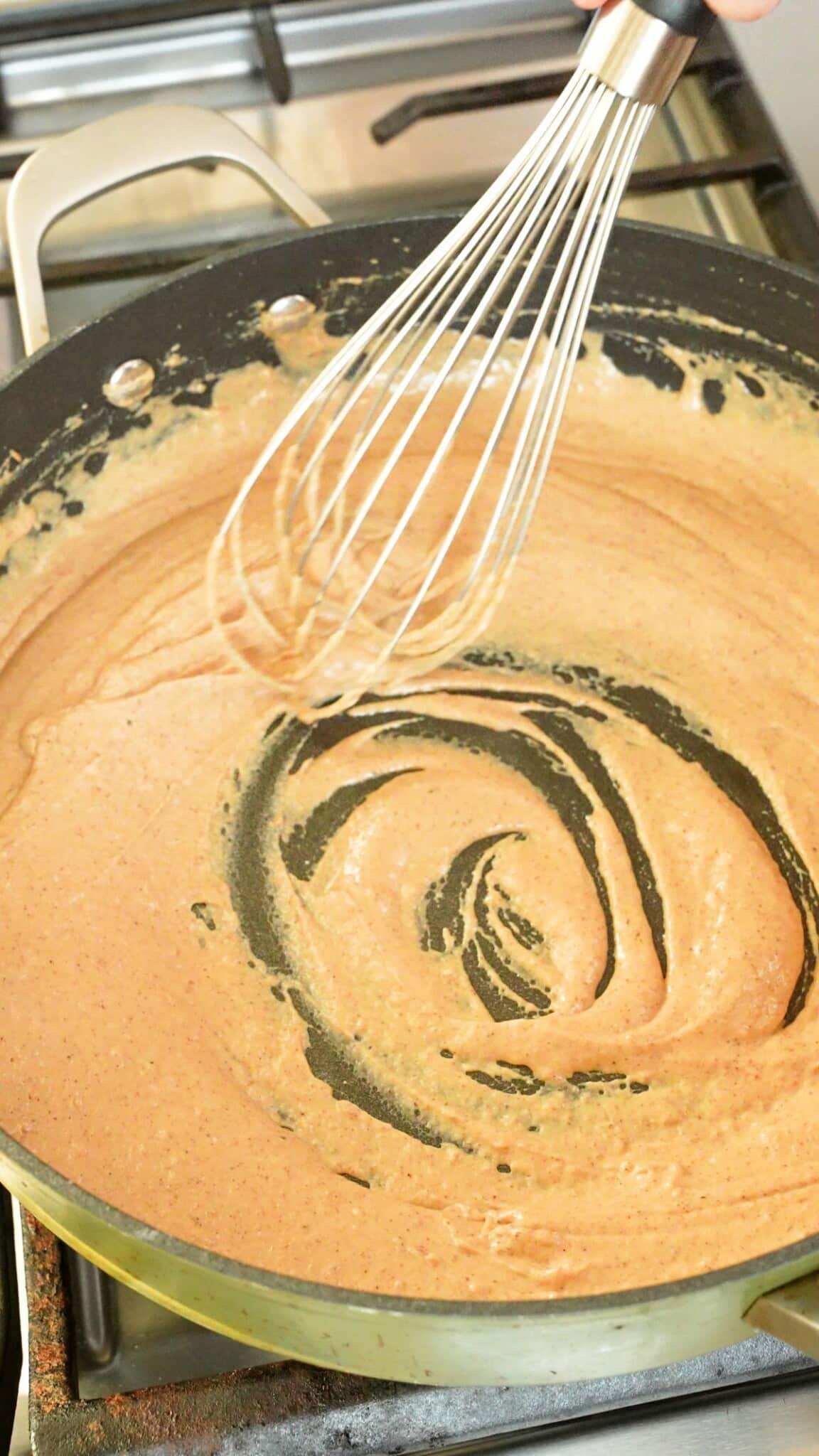 Whisking roux with evaporated milk.