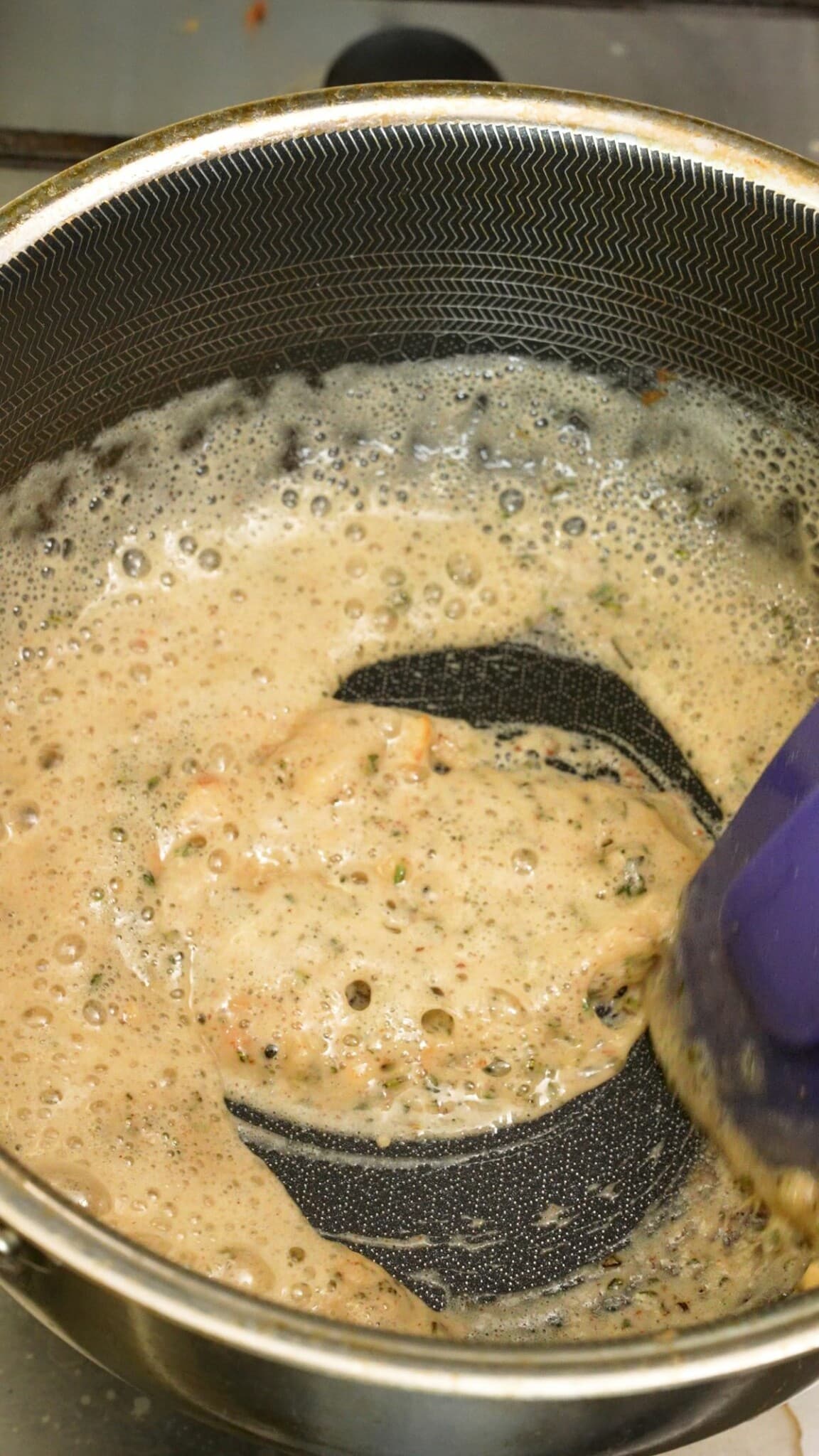 Flour being added to the roux and cooking in a pot.