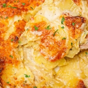 Cheesy Potatoes au Gratin in a baking dish with a spatula.