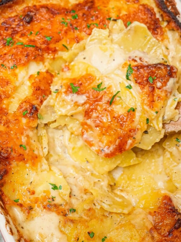 Cheesy Potatoes au Gratin in a baking dish with a spatula.