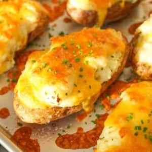 Twice Baked Potatoes on a baking sheet topped with chives.