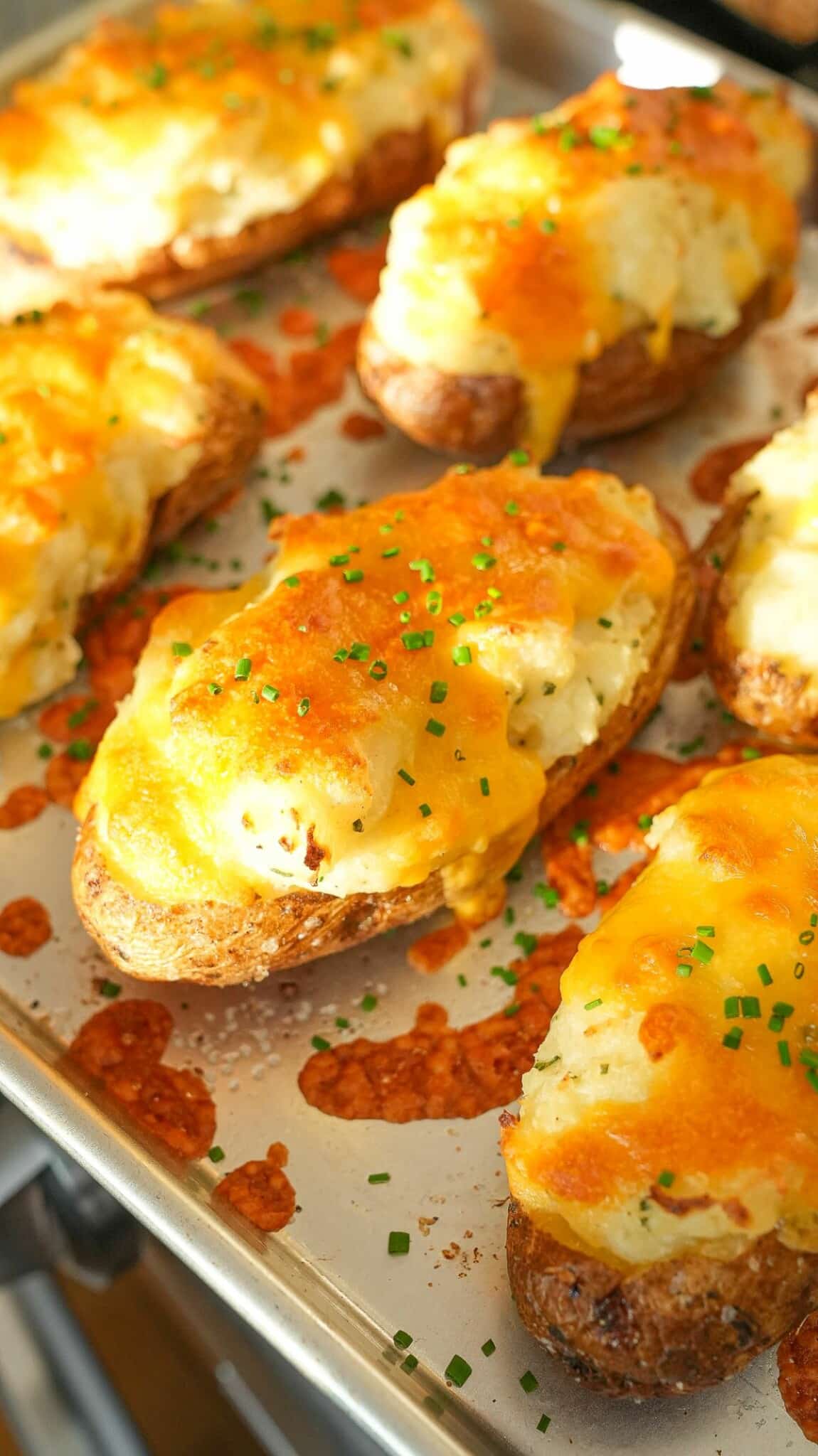 Twice Baked Potatoes on a baking sheet topped with chives.