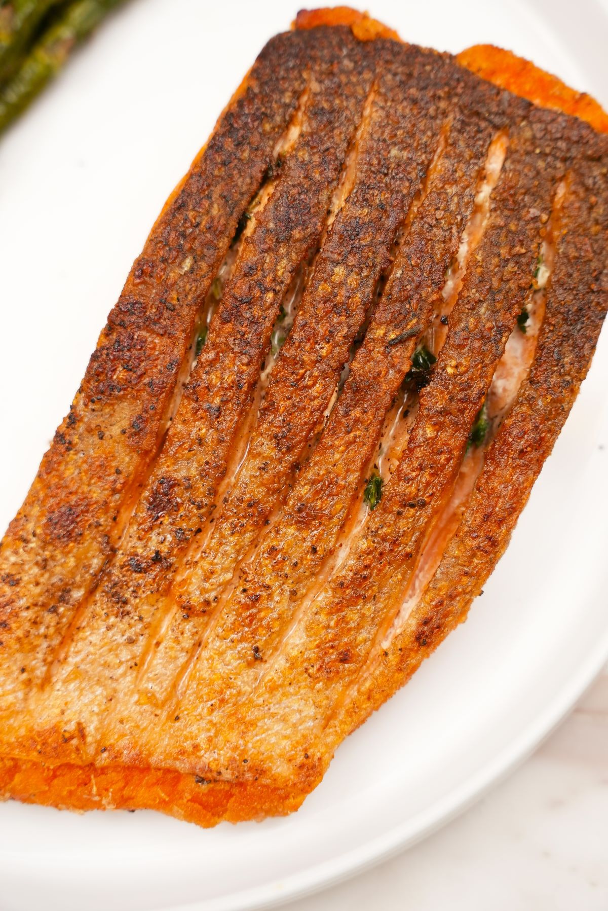 Pan seared salmon filet with crispy skin on a plate.