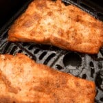 Two filets of cooked salmon in the air fryer.