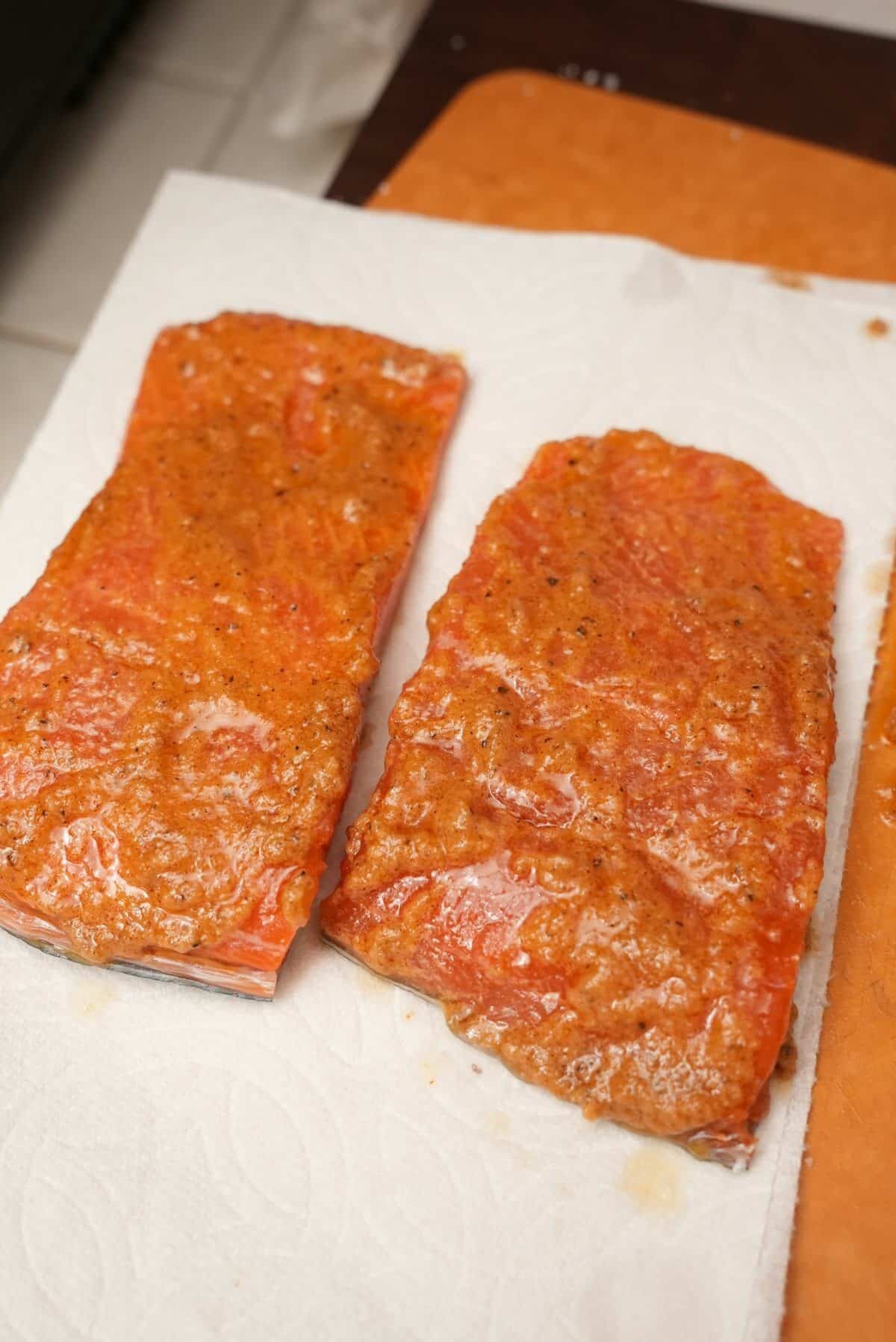 Two pieces of salmon seasoned with a spice paste.