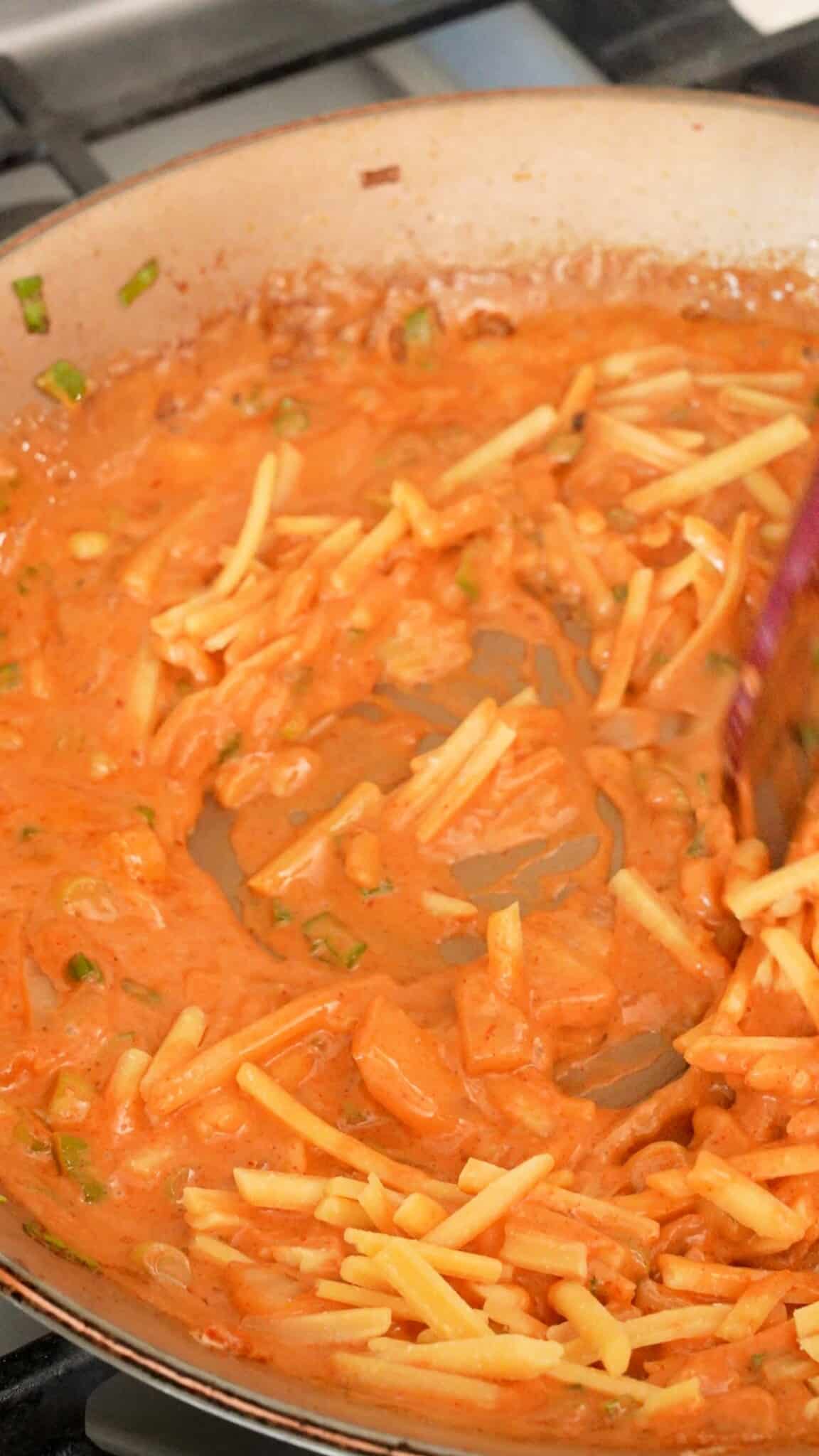 Cheddar cheese melting into the gochujang cream sauce.