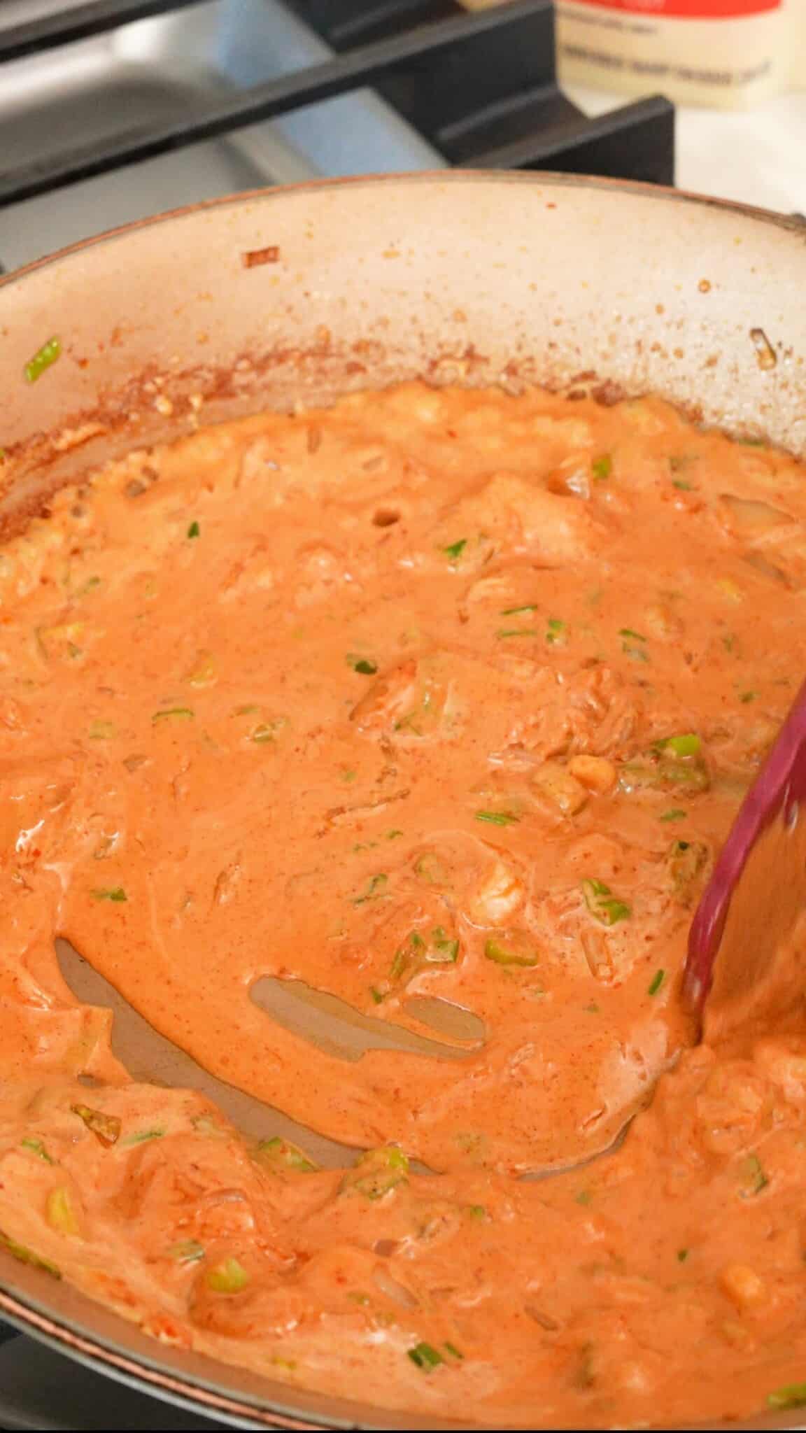 Mixing cream sauce in a pan.