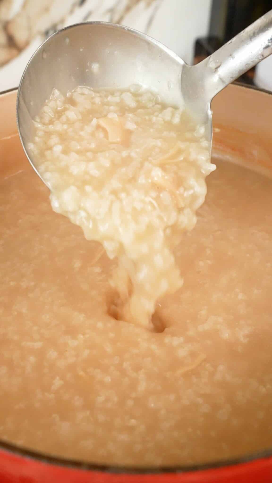 A ladle pouring Congee in a pot.