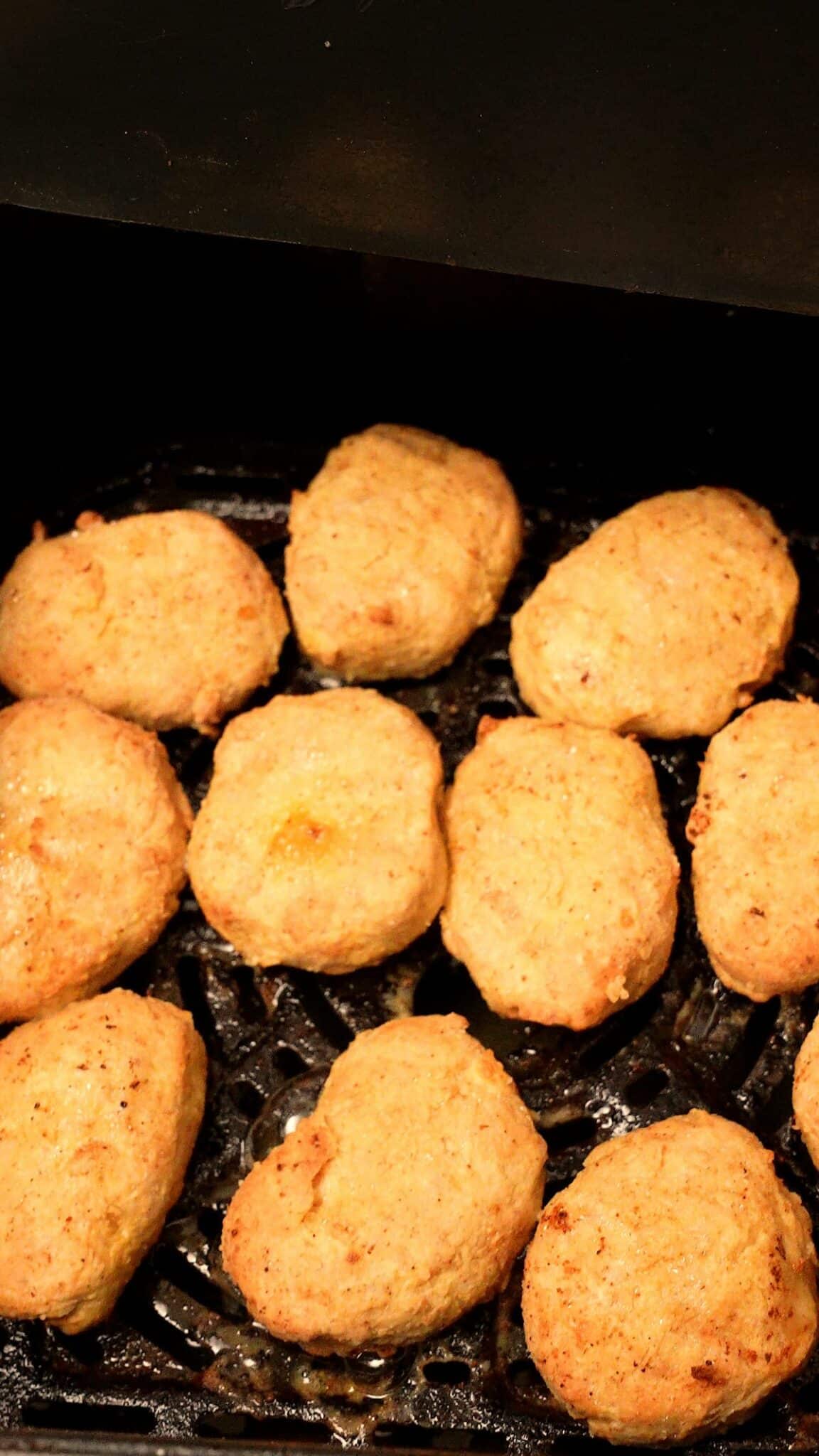 Air fried chicken nuggets in the air fryer basket.