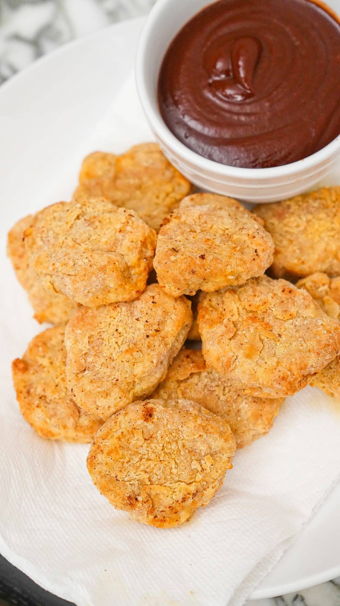 Air Fryer Chicken Nuggets on a plate with barbecue sauce.