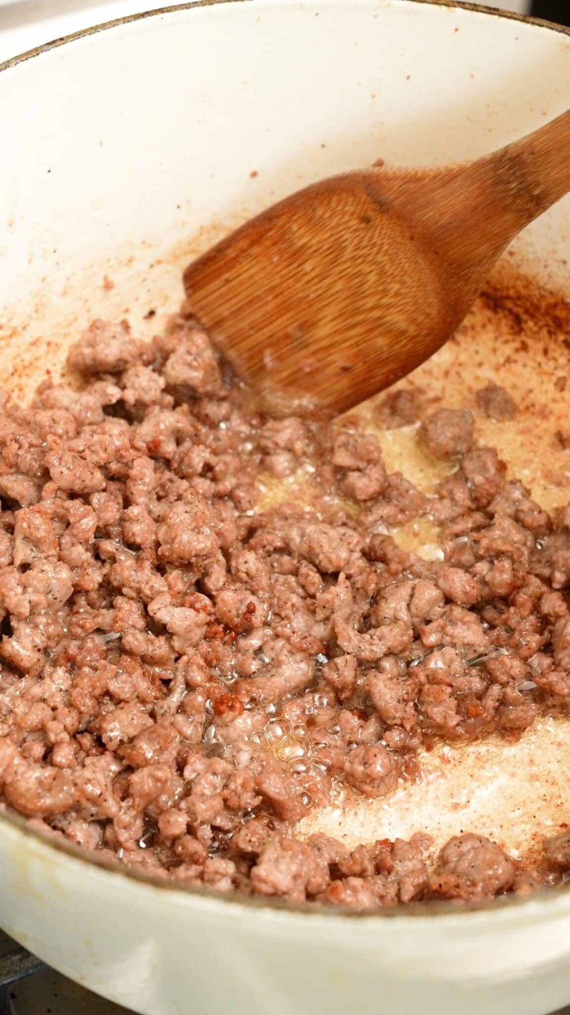 Italian sausage cooking in a pot to show crispiness.