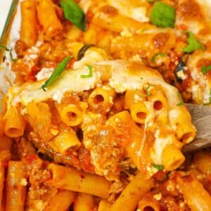 A spatula lifting up a serving of Baked Ziti from the baking dish.