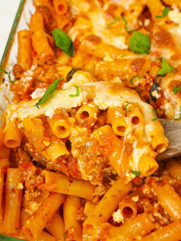 A spatula lifting up a serving of Baked Ziti from the baking dish.