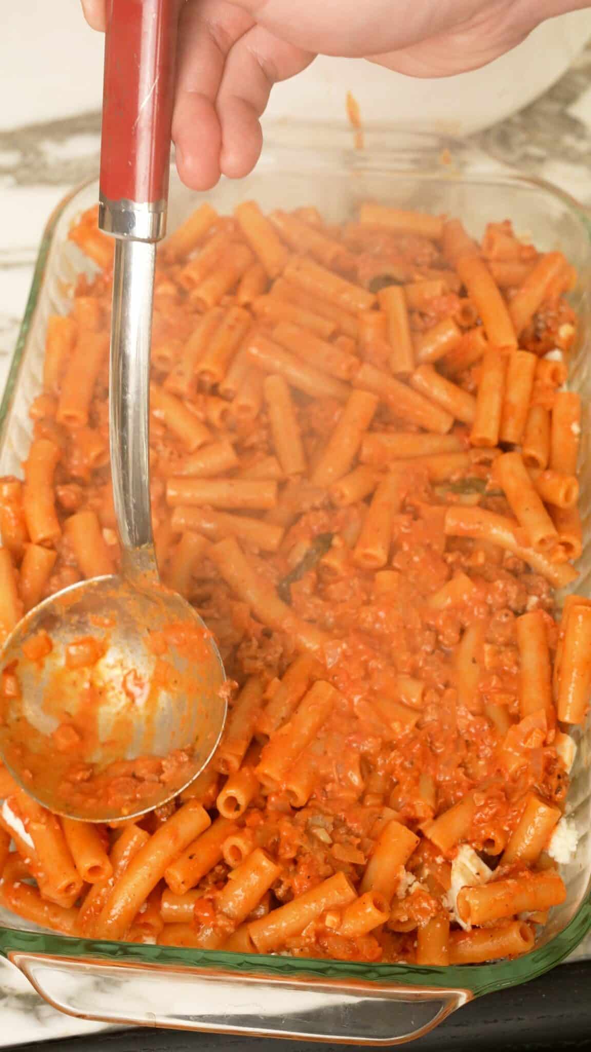 A baking dish with layered baked ziti noodles and cheese.