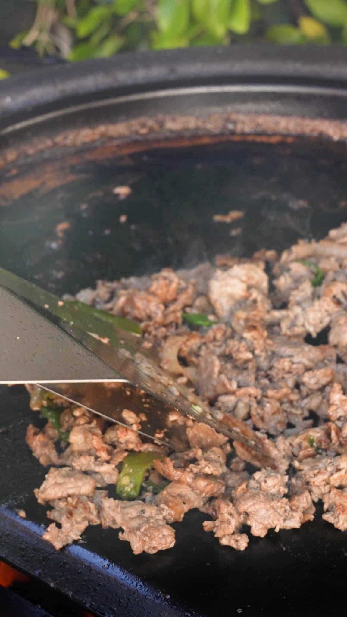 Cooking bulgogi cheesesteaks on a grill.