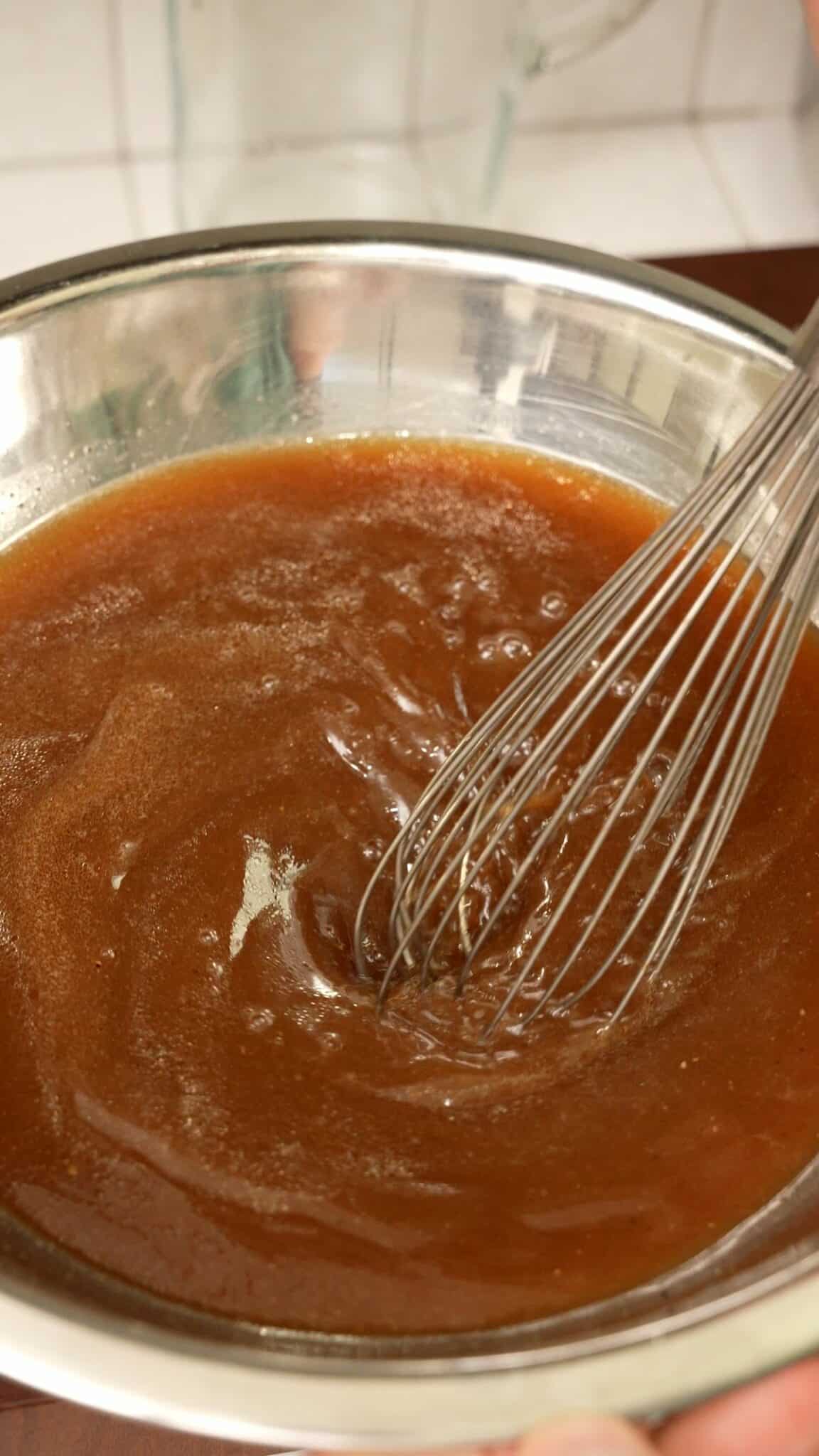 Whisking bulgogi cheesesteak marinade in a bowl.