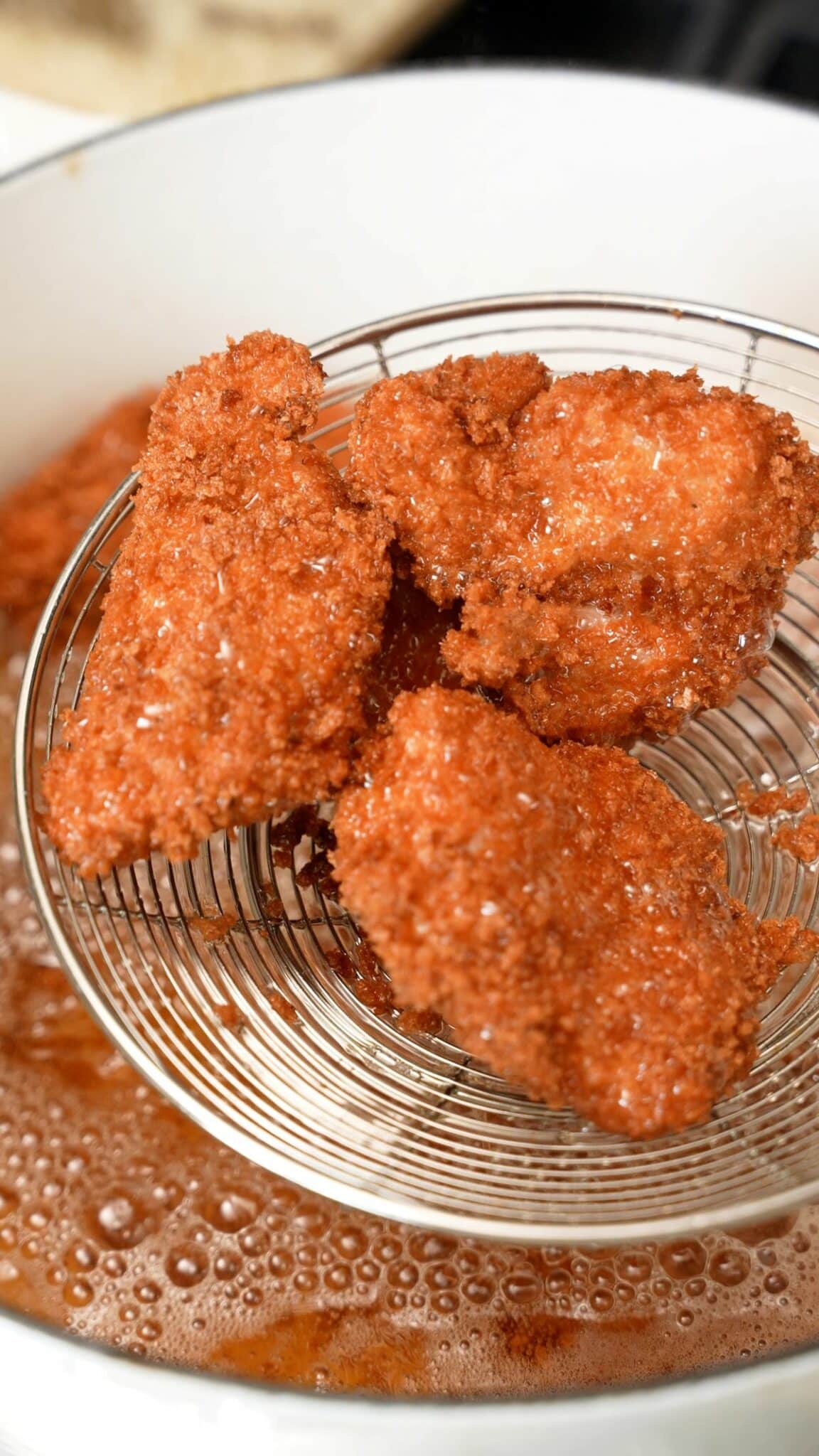 Frying the chicken katsu pieces in oil.