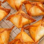 Crab Rangoons fried and on a wire rack.