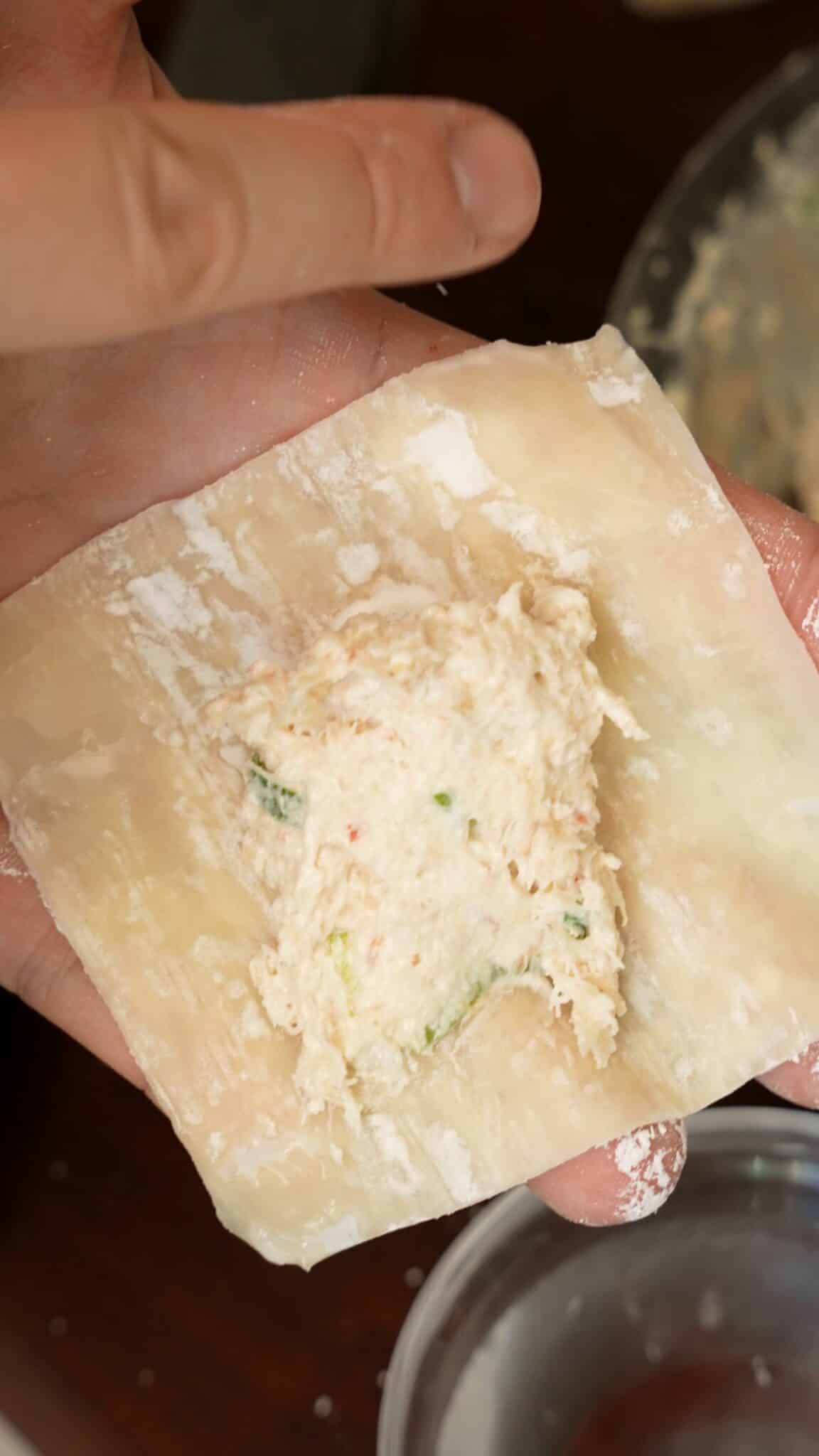 Crab Rangoon filling in the center of a wonton wrapper.