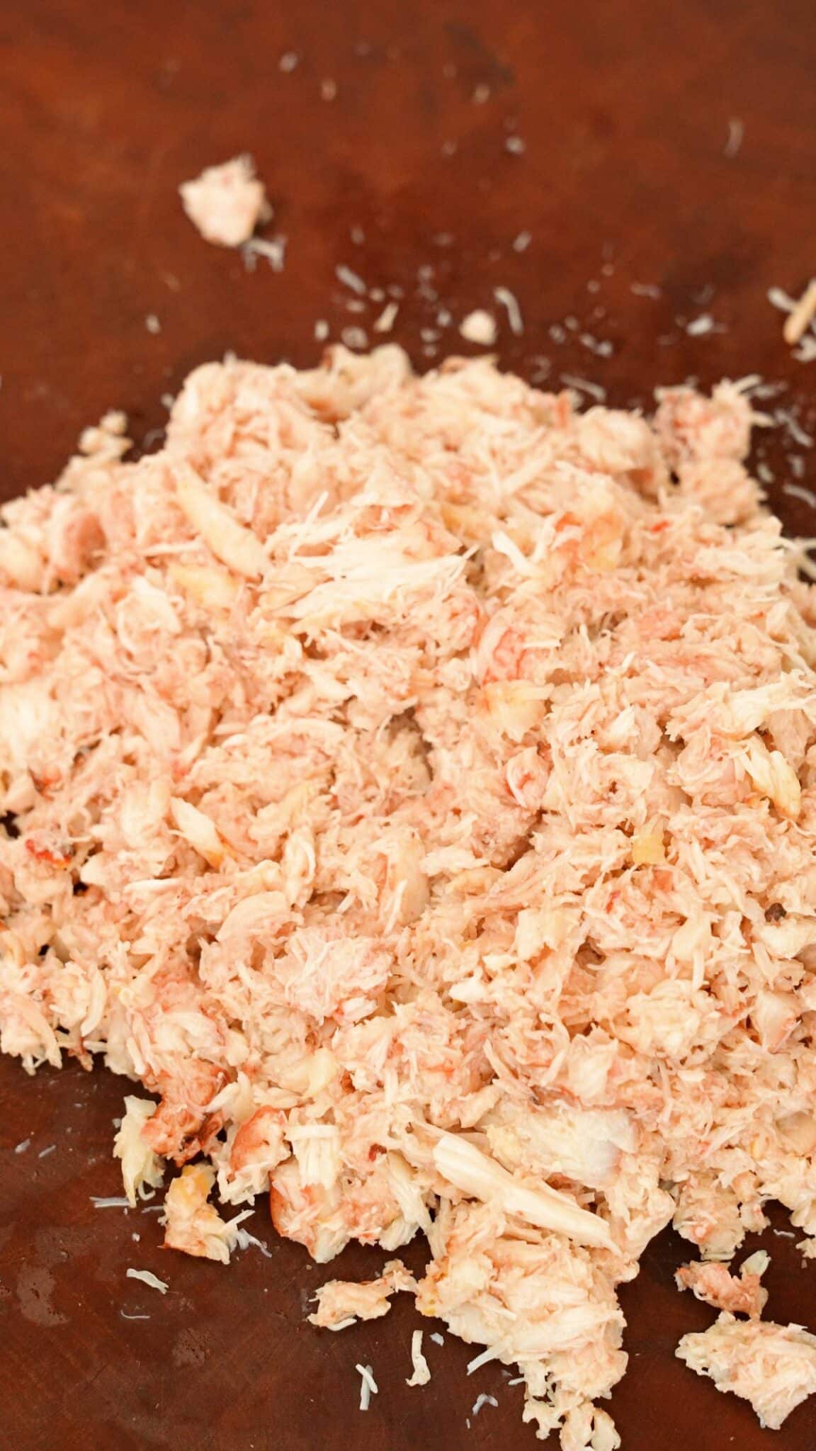 Raw crab roughly chopped on a cutting board.