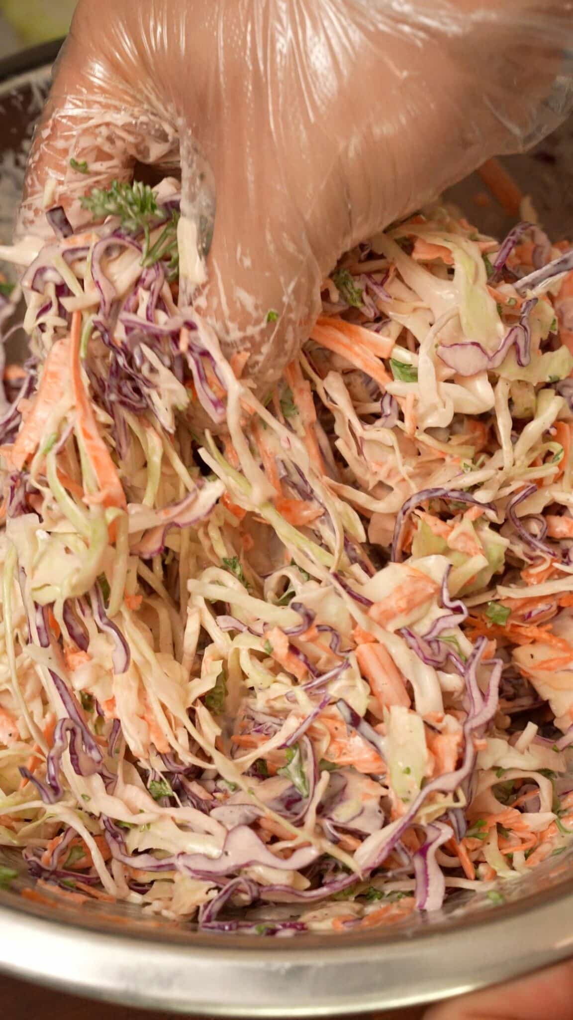 Cabbage slaw mixing in a bowl.